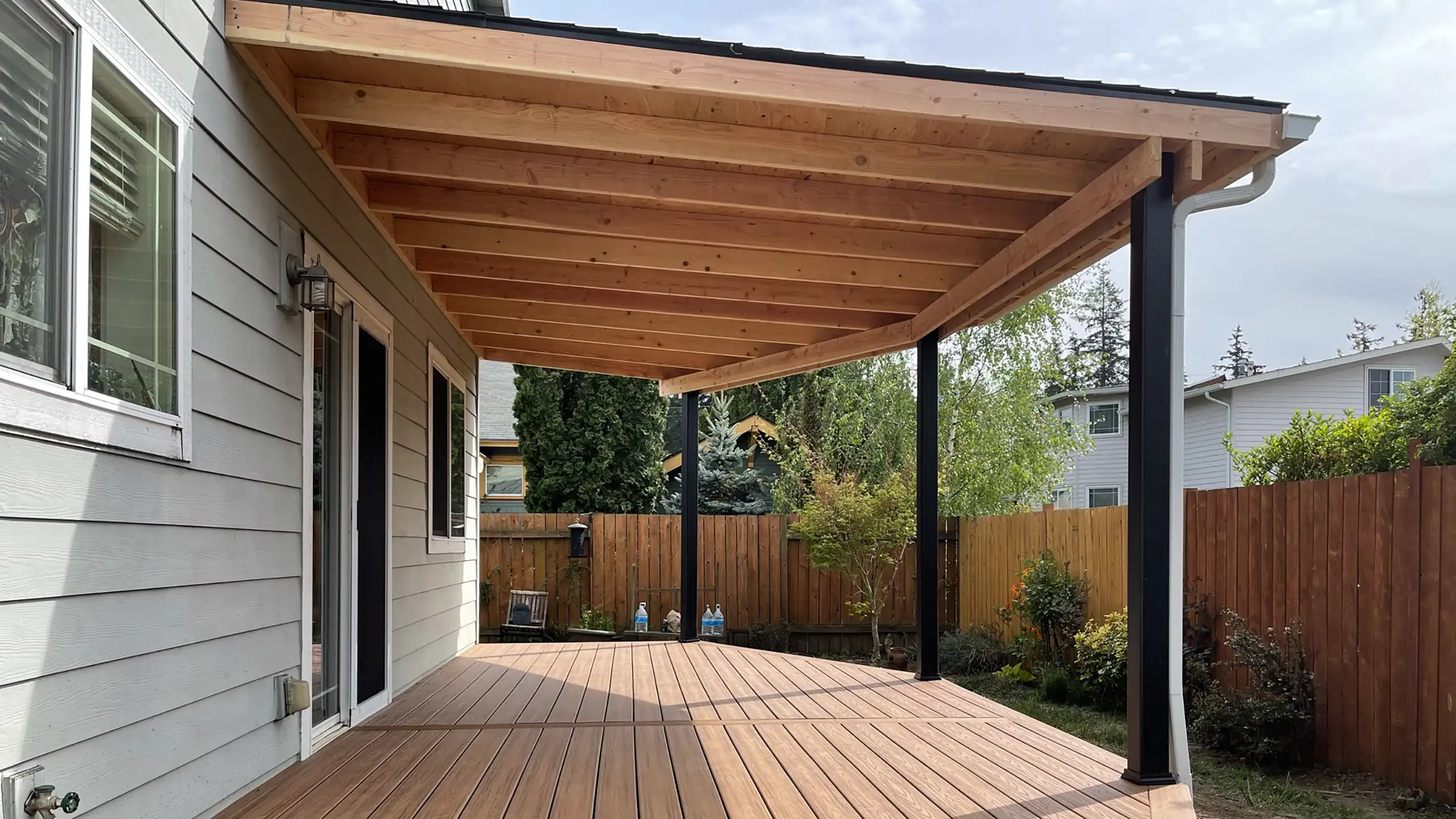 Covered residential deck with exposed wood framing and open outdoor views.