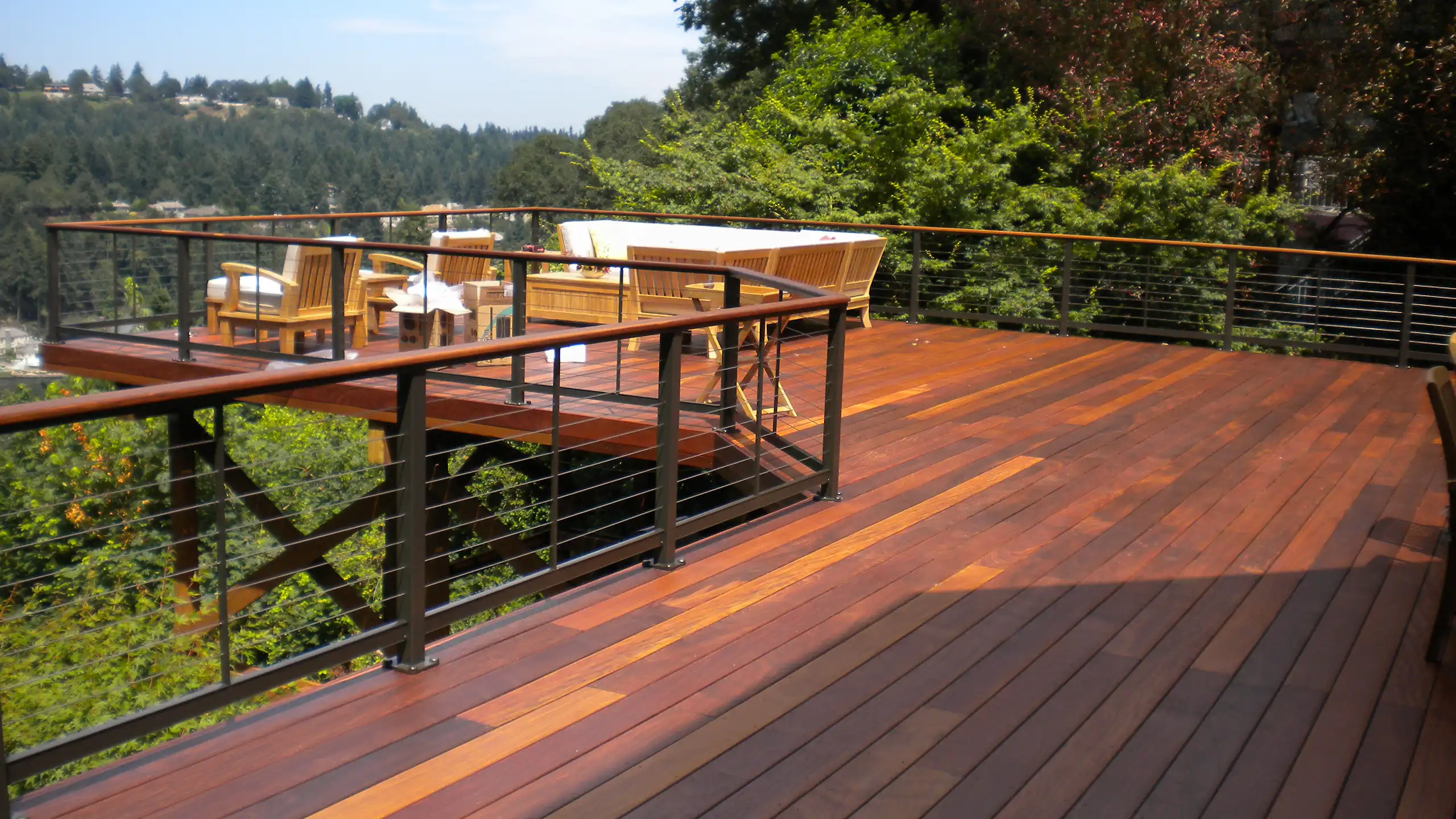 IPE hardwood deck with stainless steel cable railing overlooking a landscaped yard.